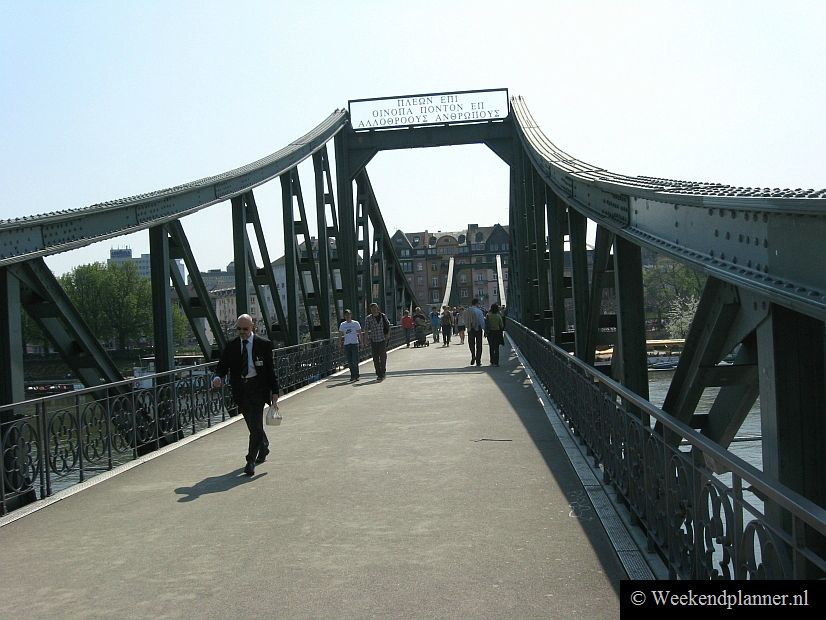 Dit is de voetbrug over de Main naar de wijk Sachsenhausen. Vlakbij de brug ligt Alt-Sachsenhausen met o.a. de straten Klappergasse en Große Rittergasse. Hier vind je prachtige historische cafés met buiten lange tafels waar je de beroemde appelwijn kunt drinken.