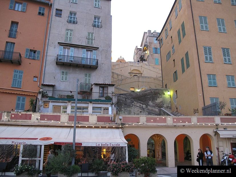 Hier zie je de trap die van de promenade bij het strand naar de Chapel de Pénitents Blancs in het historische centrum van Menton loopt.