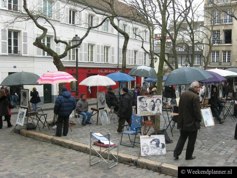 Zelfs als het regent komen er nog toeristen op de Place du Tertre. Hier kun je karikaturen laten tekenen.