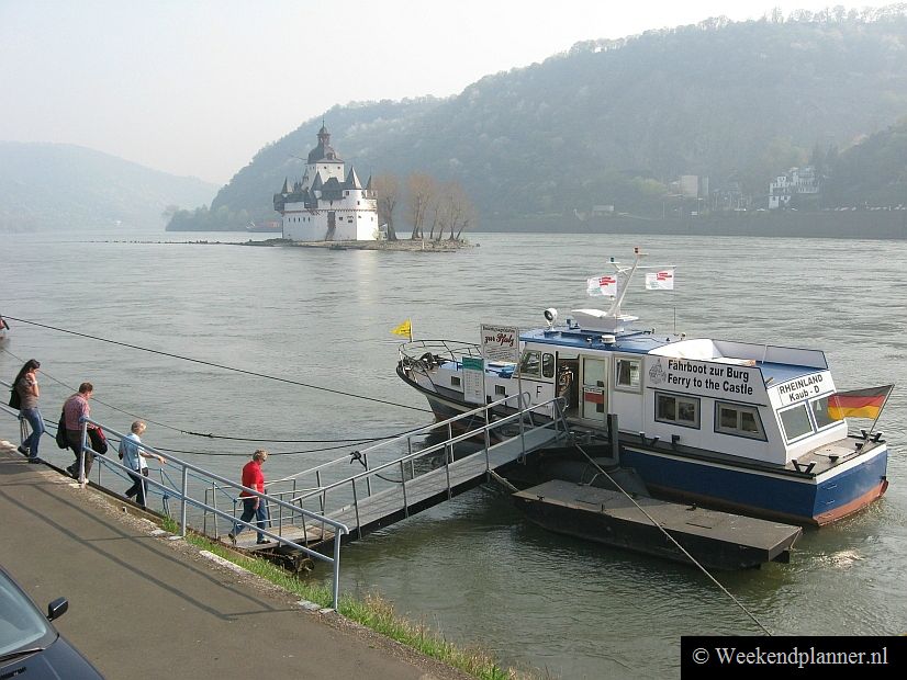 Vanaf de rivier is het Rijndal tussen Rüdesheim en Koblenz het beste te zien. Je kunt een rondvaart boeken maar leuker is het misschien om korte stukjes met een veerboot te nemen. Foto: Een veerboot naar een kasteel bij het dorp Kaub.Tip:  Rondvaarten op de Duitse Rijn.