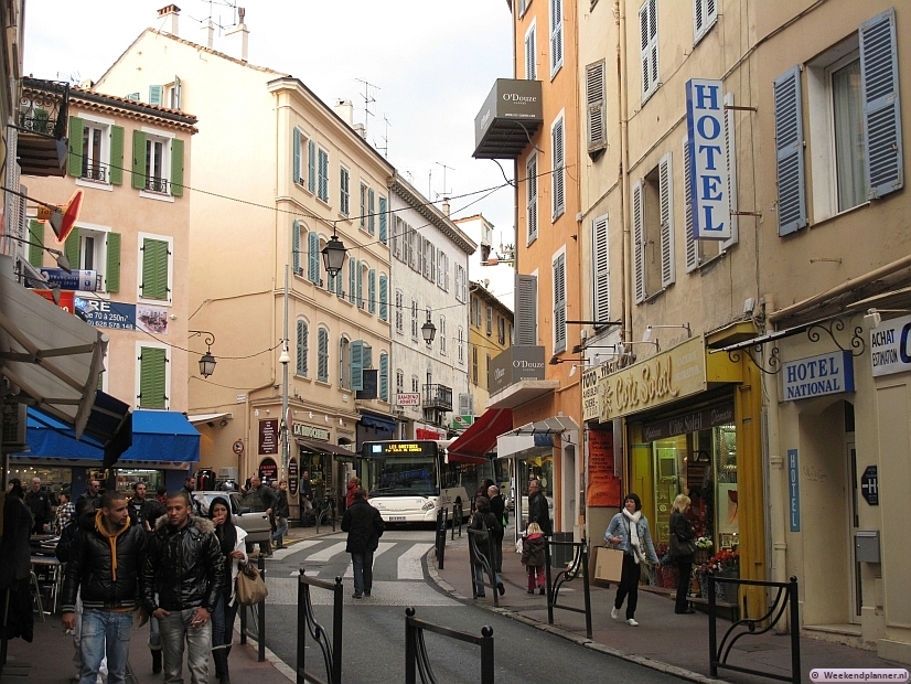De Rue du Maréchal Joffre ligt maar een paar honderd meter van de jachthaven in het centrum van Cannes. Bij het gebouw met de groene luiken begint de winkelstraat Rue Meynadier. Foto's van de winkelstraten van Cannes.