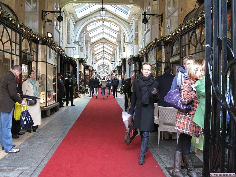 Dit is de winkelgalerij Burlington Arcade (1819) tussen Bond Street en Piccadilly. De bewaker met de hoge hoed op de foto is een "Burlington Arcade Beadle". Een Beadle beschermt je tegen fluitende, schreeuwende of  te snel lopende mensen. Tips: De historische winkelgalerijen rond Mayfair.