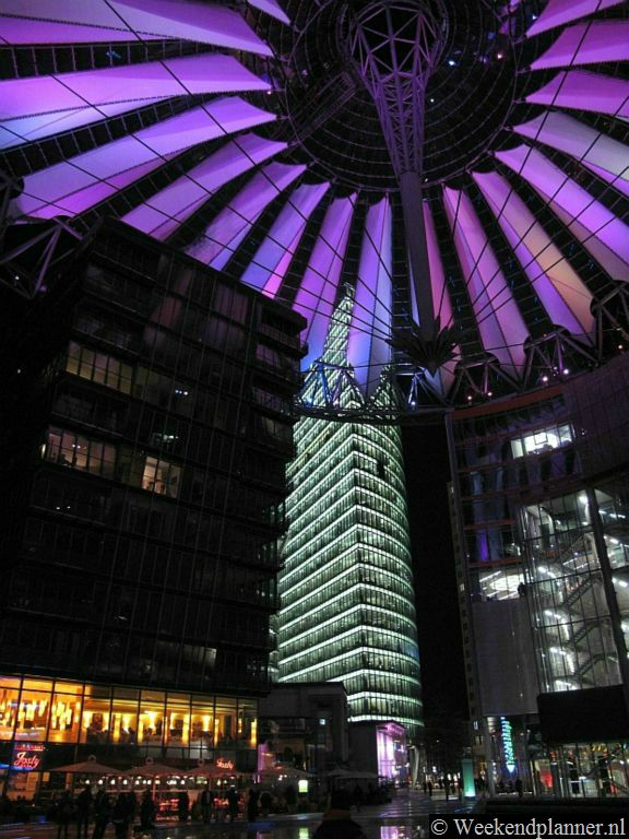 Op de Potsdamer Platz kun je uitgaan en winkelen. Op de foto zie je het Sony Center met een bioscoop met Engelstalige films en veel restaurants. Het dak bestaat uit zeildoek dat in de nacht in wisselende kleuren verlicht wordt.  Foto's van een bezoek aan de Potsdamer Platz.