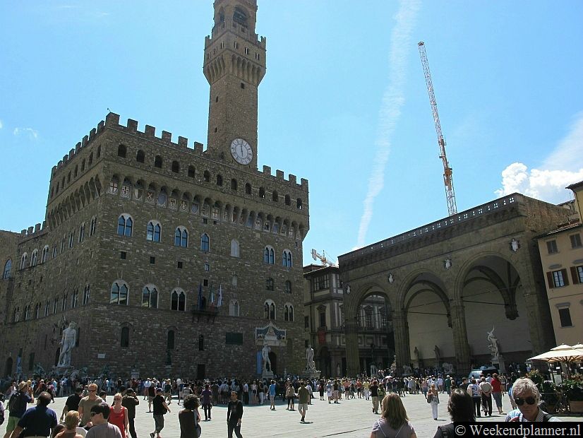 Het plein Piazza della Signoria ligt vlakbij de brug Ponte Vecchio en het museum Galleria Degli Uffizi in het historische centrum van Florence. Speciale bezienswaardigheden op dit plein zijn het paleis Palazzo Vecchio (links) en de beeldengalerij Loggia dei Lanzi (rechts). Tips: Deze bezienswaardigheden moet je niet missen in Florence.