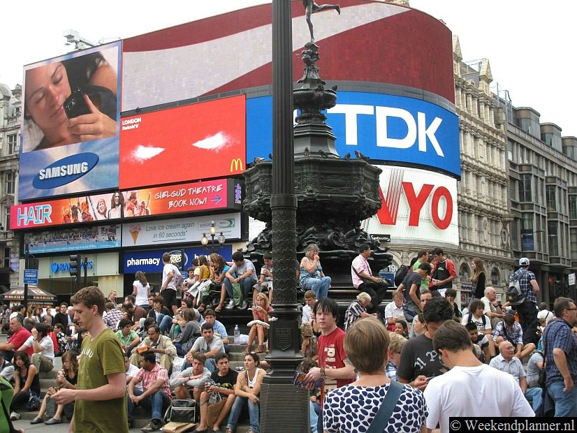 Dit is het bekende beeld van Piccadilly Circus, veel mensen en lichtreclames.Tip: De attracties rond Piccadilly Circus.