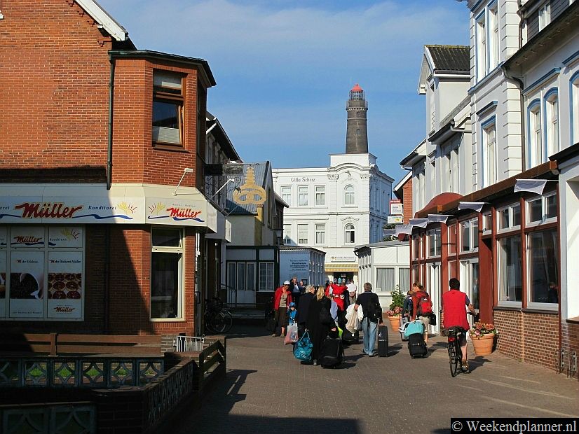 Een straat op Borkum. Op de achtergrond de vuurtoren.  Vanaf de vuurtoren heb je een mooi uitzicht over het eiland.Foto's van de attracties van Borkum.