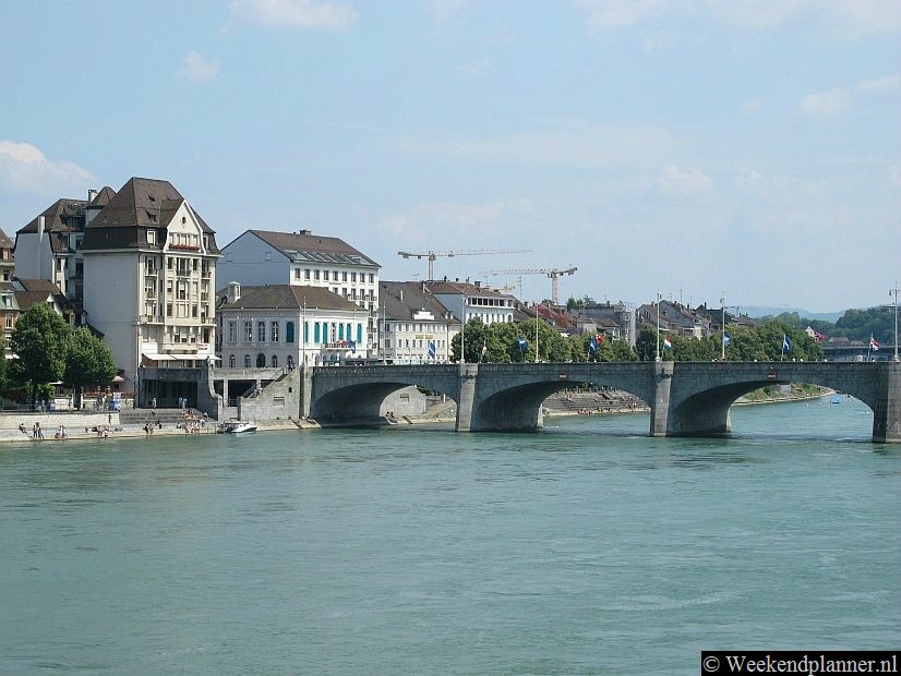 De Rijn stroomt door het historische centrum van Bazel. Op de noordelijke oever ligt de wijk Kleinbasel. Op de oever zijn veel restaurants en cafés. Bij de Mittlere Brücke liggen enkele hotels. Als je de brug oversteekt kom je in de historische binnenstad van Bazel.Foto's van de Rijn in Bazel.