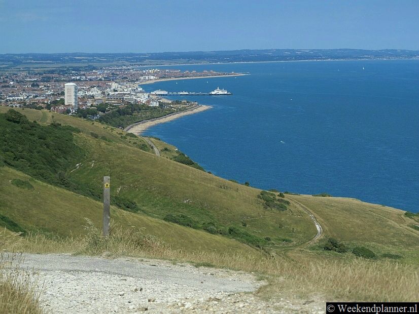 Dit is de badplaats Eastbourne gezien vanaf de witte krijtrotsen. Op de foto zie je het strand en de Victoriaanse pier van Eastbourne.Tip: De badplaats Eastbourne.