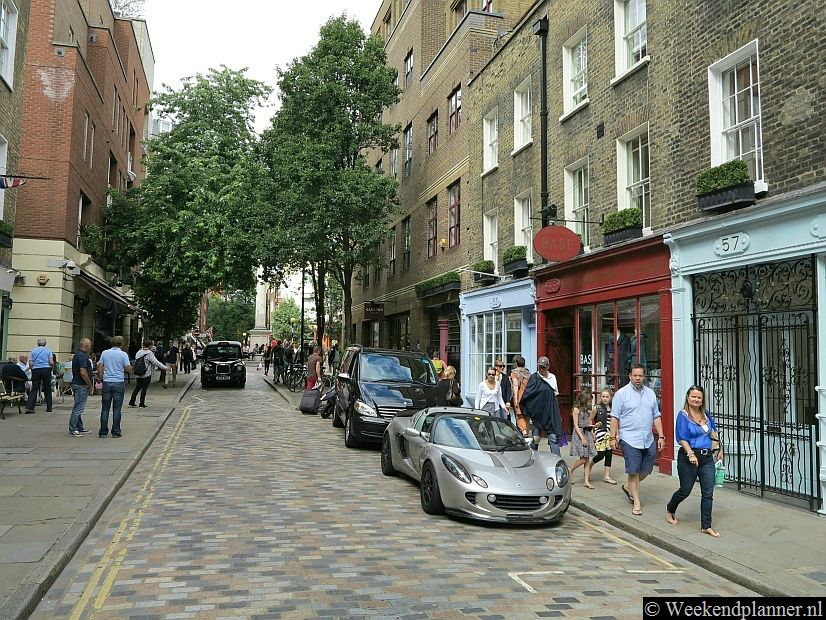 Monmouth Street met op de achtergrond het monument van Seven Dials.Tip: De omgeving van Covent Garden.
