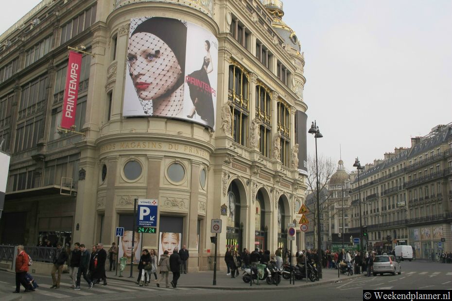 In de lange winkelstraat Boulevard Haussman in Parijs zijn veel beroemde winkels te vinden. Op de foto ziet u het grote warenhuis Printemps.Tips: Winkelen in Parijs..