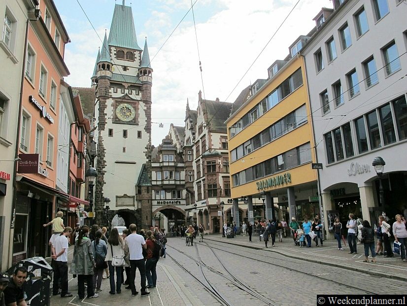 Freiburg heeft een prachtig historisch centrum.  Op de foto zie je de winkelstraat Kaiser Joseph Strasse met de middeleeuwse stadspoort Martinstor.Tip: De attracties van Freiburg.